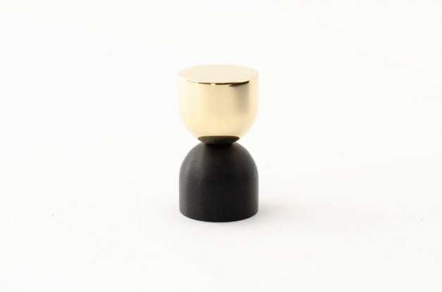 kokeshi är en knopp eller krok i två olika material, svart aluminium samt polerad mässing