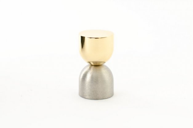 kokeshi är en knopp eller krok i två olika material, svart aluminium samt polerad mässing